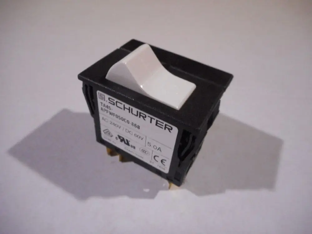 Schwarzer Schalter von Remeha mit einer weißen Betätigung, ausgestattet mit Anschlussklemmen auf der Unterseite und einem Typenschild mit technischen Angaben.
